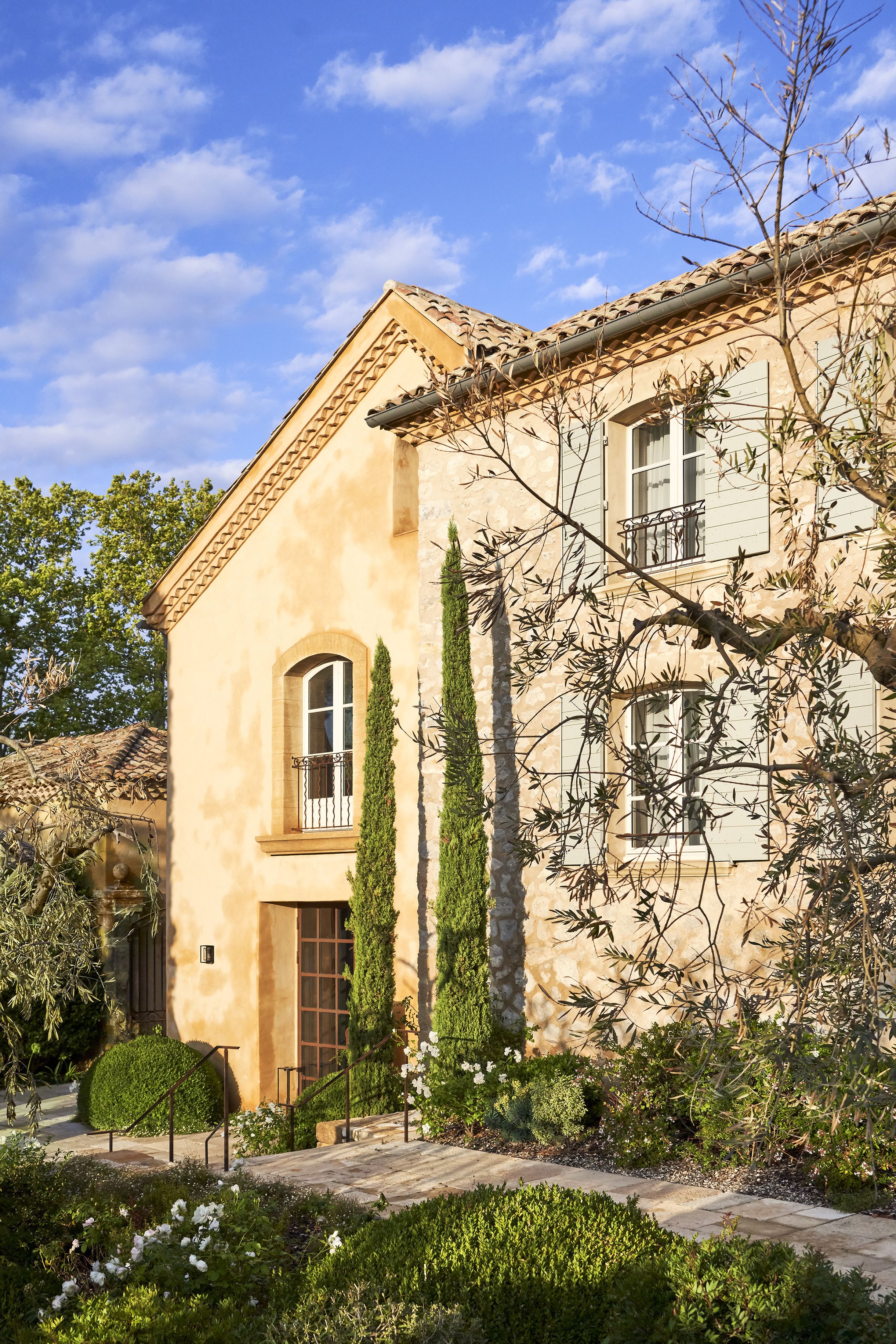Un bâtiment de style méditerranéen, avec une façade en stuc, un toit en tuiles et un petit balcon.