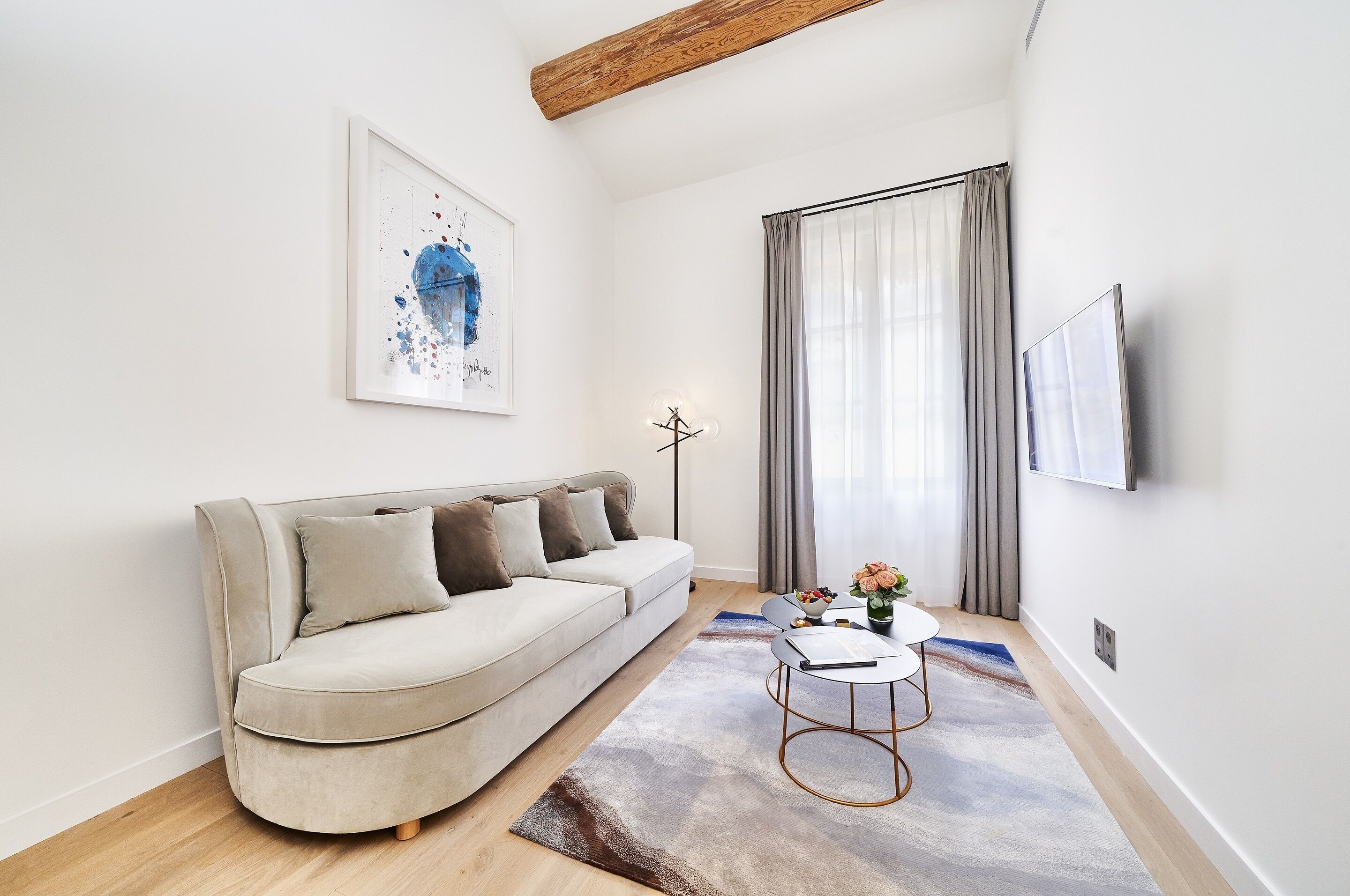 Uma sala de estar moderna com um sofá, uma mesa de centro e um quadro na parede.