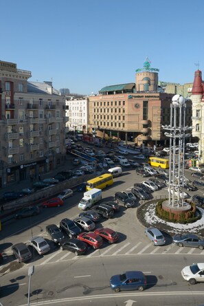 A busy urban intersection with multiple lanes of traffic, including cars, buses, and a tram. - Partner Guest House Velyka Vasylkivska (Kyiv)