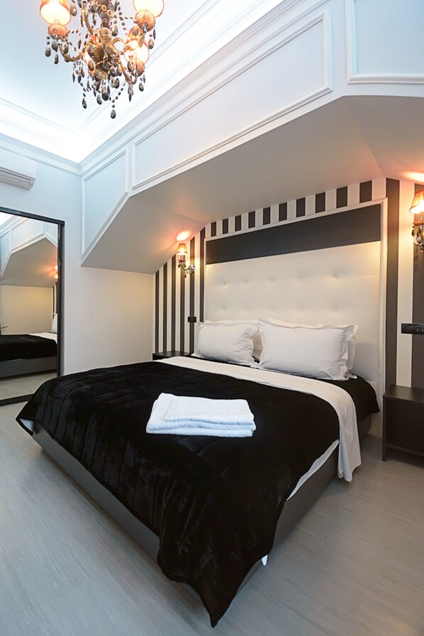 A modern bedroom with a large bed, a chandelier, and a mirror. - Partner Guest House Velyka Vasylkivska (Kyiv)