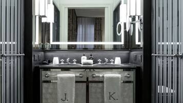 Une salle de bain moderne avec un double lavabo, un grand miroir et des porte-serviettes.