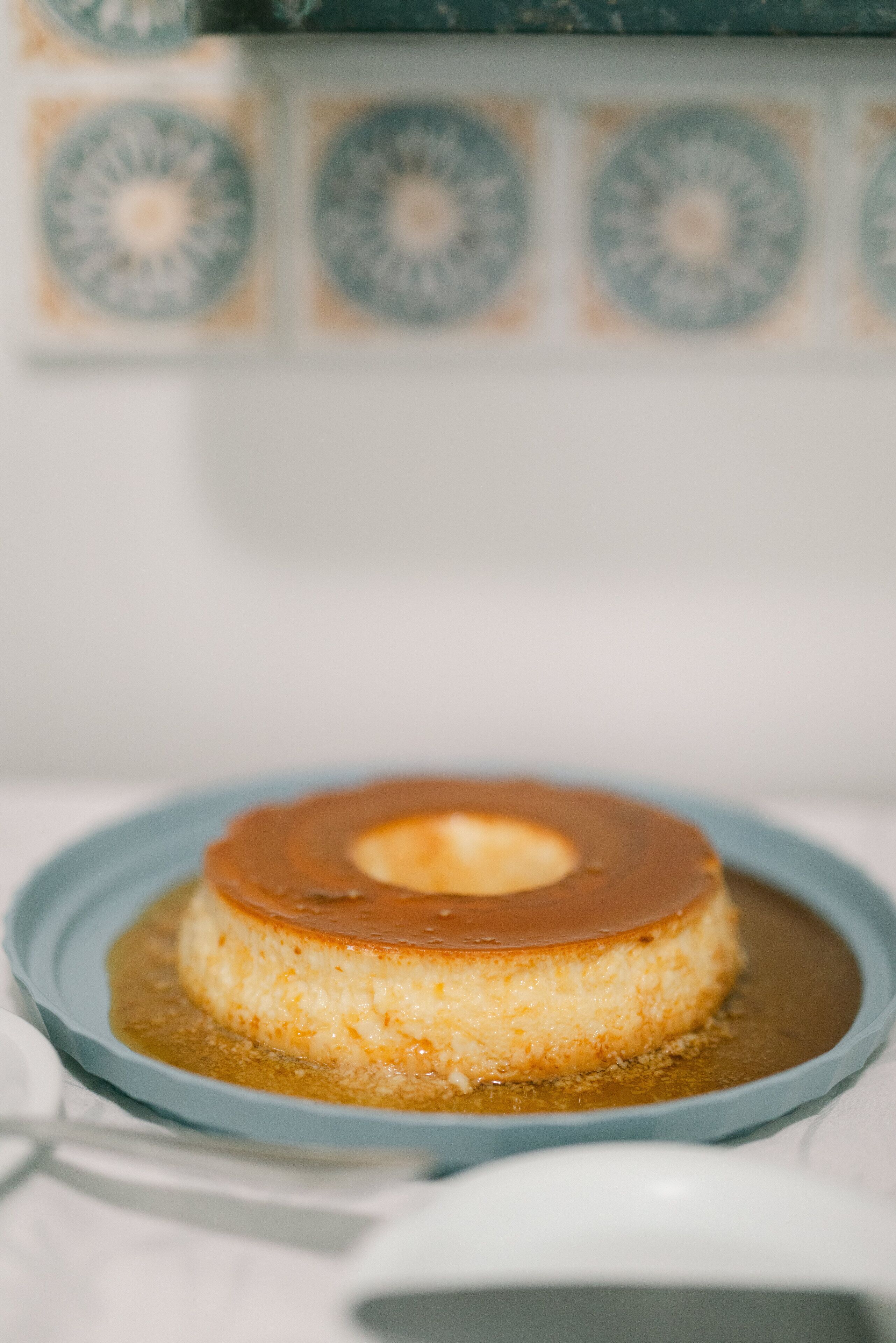 Een caramelpudding op een blauw bord.