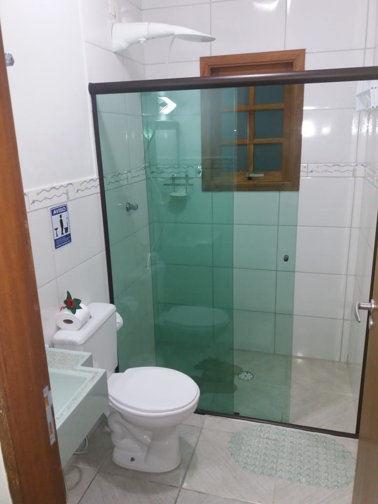 Un bagno piccolo con un WC, uno spazio doccia in vetro e una finestra.