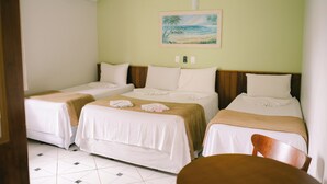 A hotel room with two single beds, a wooden headboard, a painting of a beach scene, and a tiled floor. - Hotel Kiribati (São Sebastião)