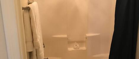 A bathroom with a bathtub, a toilet, and a shower curtain.