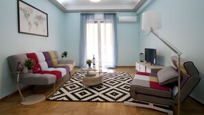Un salon moderne avec un canapé, une table basse et un téléviseur.