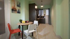 Un coin repas comprenant une table, deux chaises et une petite plante.