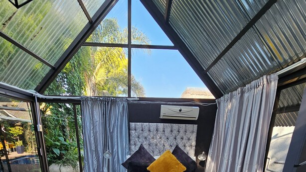 A bedroom with a bed, a large window, and a view of the outdoors. - 51 on Church Guesthouse (Matjhabeng)