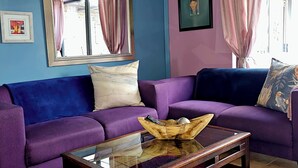 A living room with a purple sofa, a glass coffee table, and a purple rug. - 51 on Church Guesthouse (Matjhabeng)