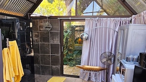 A modern, open-plan living space with a glass ceiling, a yellow armchair, a dining area, and a kitchen area. - 51 on Church Guesthouse (Matjhabeng)