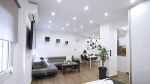 A modern living room with a sofa, coffee table, and a dining area with chairs and a table. - Α Koukaki, Modern Newly Refurbished Apartment (Athens)