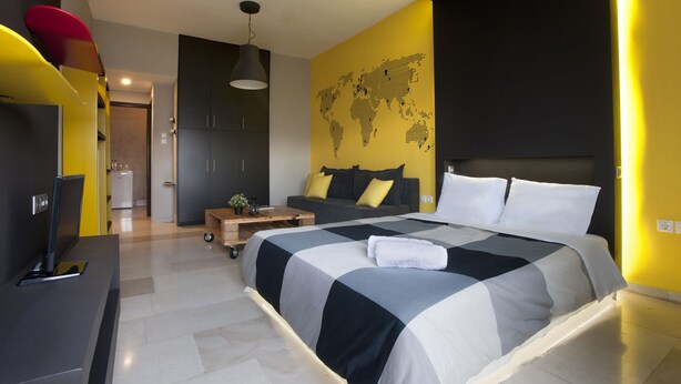 Une chambre à coucher moderne avec un grand lit, une carte du monde accrochée au mur et un bureau avec une télévision.
