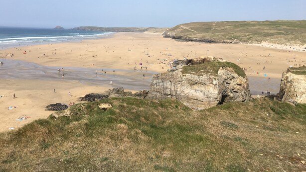 A wide beach with rocky outcrops and grassy areas. - St George's Hotel (Perranporth)