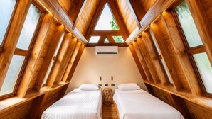 A room with two beds, wooden beams, and large windows. - Golden Sands Destination Resorts (Daanbantayan)