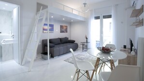 A modern living space with a loft bedroom, a dining area, and a kitchen. - Victoria Square, Cozy and Stylish Apartment (Athens)