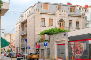 A building with a parking sign, a pedestrian crossing sign, and a Tommy Hilfiger store. - Flos Luxury Rooms (Split)
