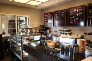 Mostrador de una cafetería con un panel que muestra diferentes opciones de café y té.
