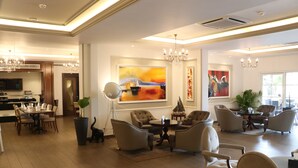 Amplia sala de estar con comedor, muebles modernos y obras de arte en las paredes.