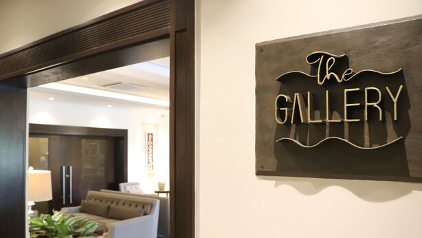 Un pasillo con un cartel en la pared que dice 'The Gallery'.
