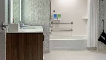 Une salle de bain moderne avec un meuble-lavabo en bois, un lavabo blanc et une cabine de douche en verre.