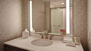Un baño moderno con un espejo grande, un lavabo y una zona de ducha.
