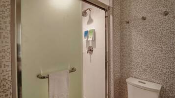 A bathroom with a shower, toilet, and towel rack.