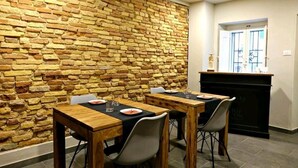Un comedor con pared de ladrillo, mesas y sillas de madera.