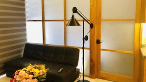 A room with a sofa, a floor lamp, and a floral arrangement. - Modern studio in Puerto Vallarta Down Town (Puerto Vallarta)