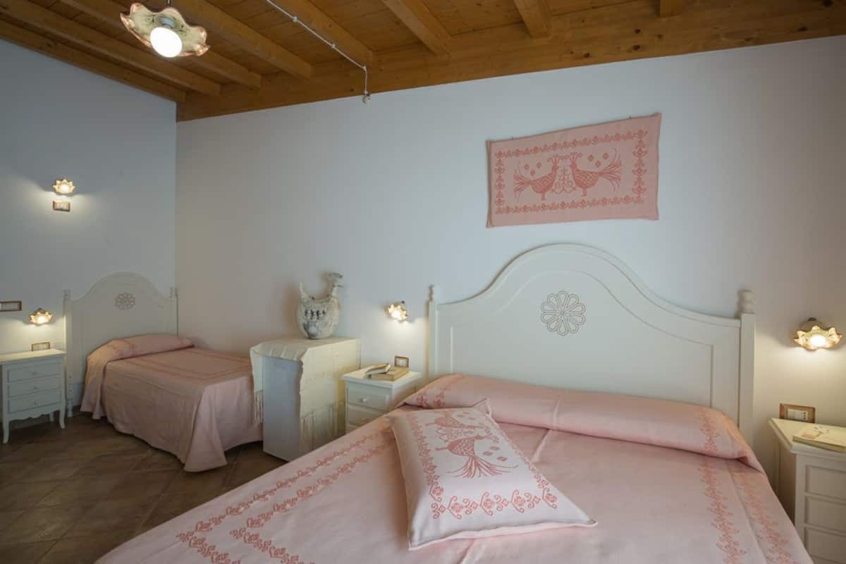 A bedroom with two beds, each with a matching headboard and bedside tables.