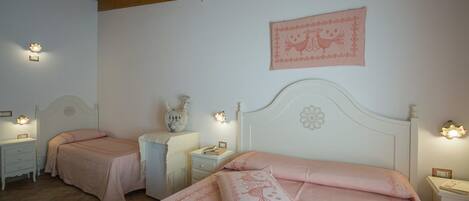 A bedroom with two beds, each with a matching headboard and bedside tables.