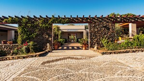 Un arco in pietra conduce a un edificio con la scritta "Hotel Barbagia".