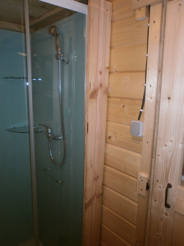 A wooden cabin with a glass shower enclosure and a wooden door. - Camping Manex - Cabanes (Saint-Pee-sur-Nivelle)