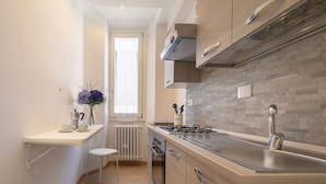 Una cocina moderna con estufa integrada, pileta de acero inoxidable y alacenas de madera.