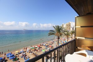 A beach with umbrellas and people, a clear sky, and a view of the sea. - Hotel Bilbaino (Benidorm)
