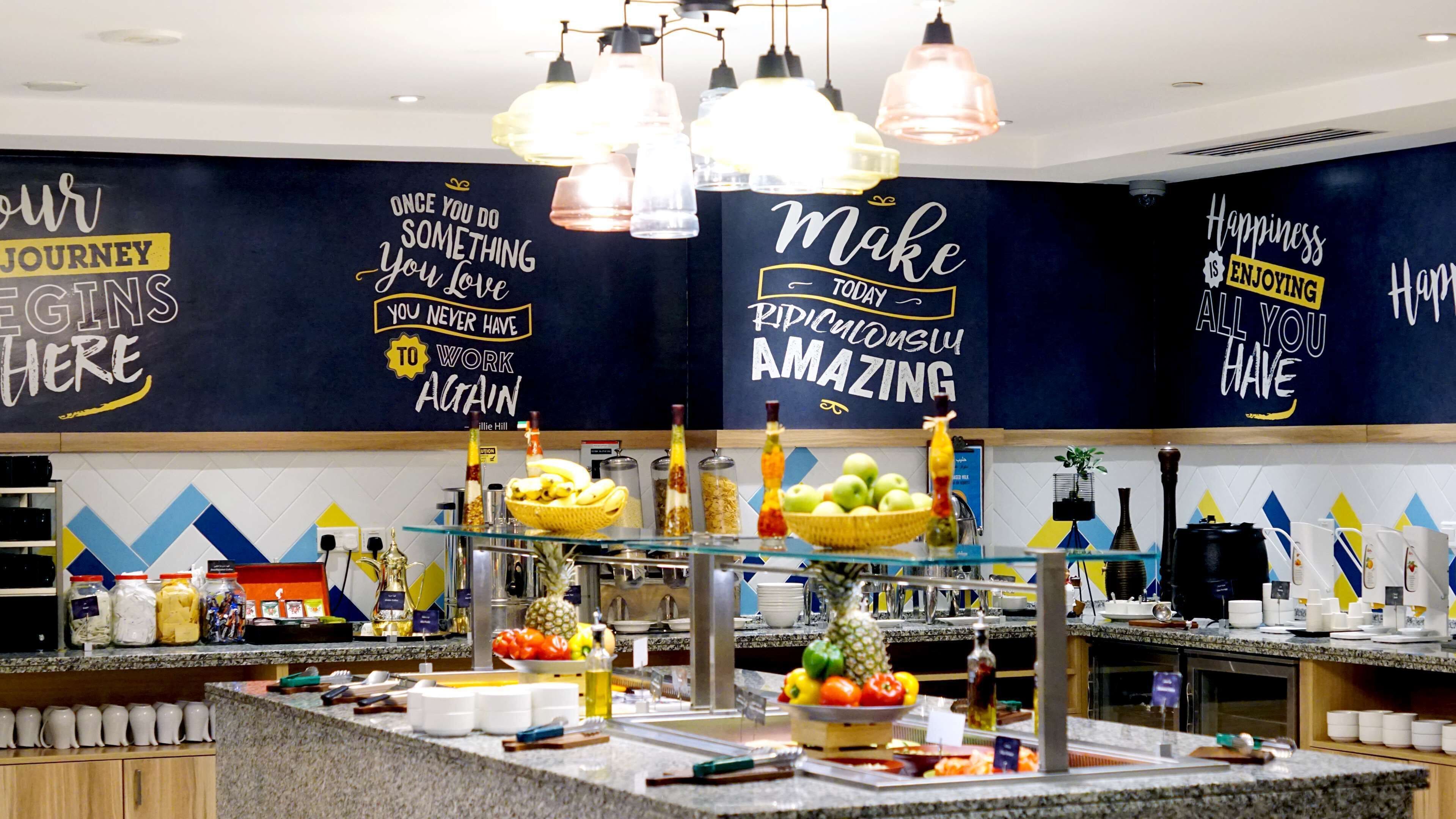 Zona de buffet con diferentes opciones de comida y decoración mural inspiradora.