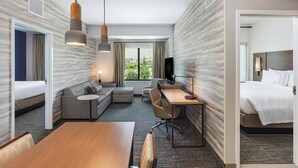 Une chambre d’hôtel comprenant un lit, un bureau, un canapé, une table à manger et un téléviseur.