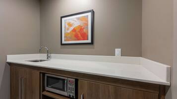 A kitchen with a built-in microwave, a sink, and a countertop.