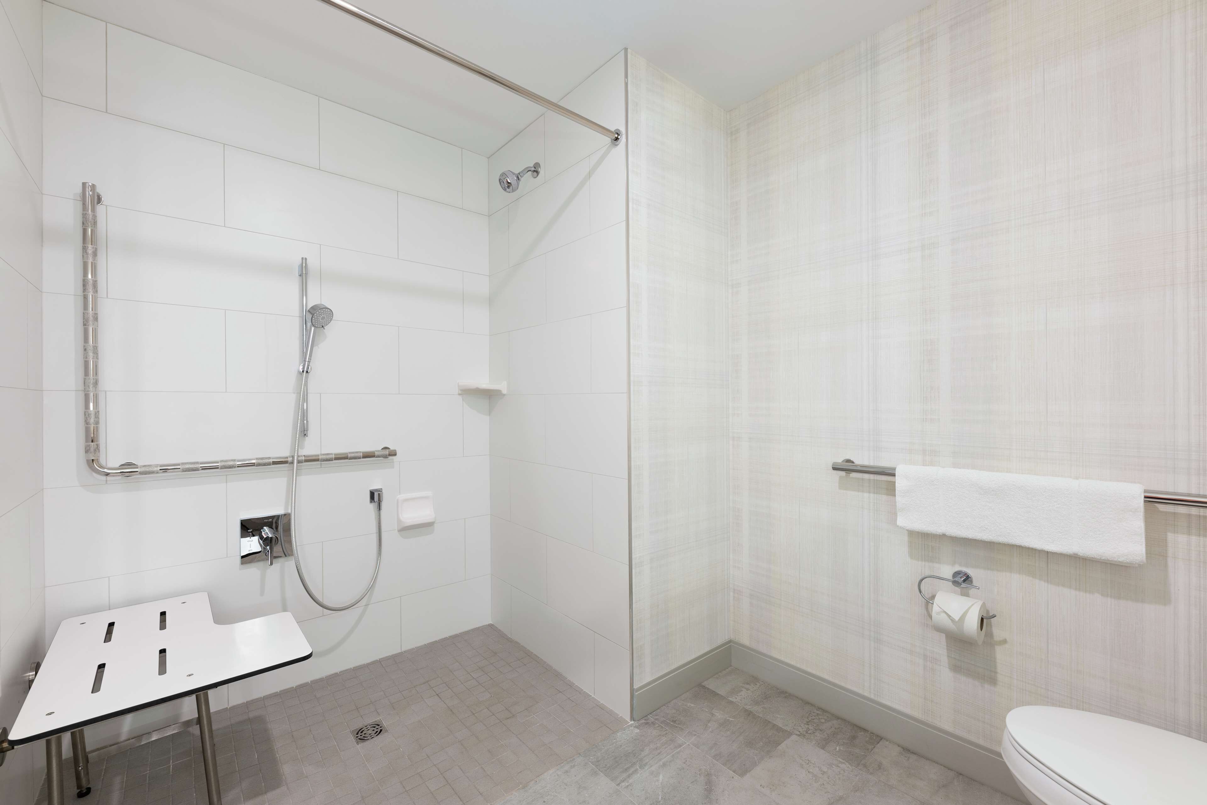A modern bathroom with a glass shower enclosure, a white sink, and a toilet.