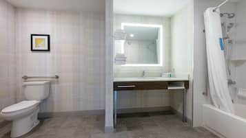 A modern bathroom with a toilet, sink, and shower.