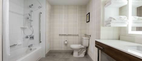 A modern bathroom with a bathtub, toilet, and shower area.