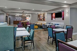 A modern hotel lobby with a reception desk, seating areas, and a TV mounted on the wall. - Hampton Inn Weslaco (Weslaco)