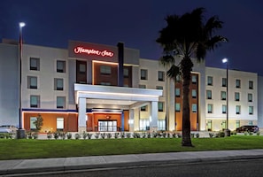 A modern hotel with a prominent neon sign, a covered entrance, and a well-maintained lawn. - Hampton Inn Weslaco (Weslaco)