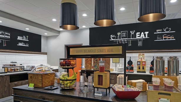 Un espace proposant un buffet pour le petit-déjeuner, avec une pancarte indiquant : « ICI, VOTRE PETIT-DÉJEUNER COMMENCE EN BEAUTÉ. »