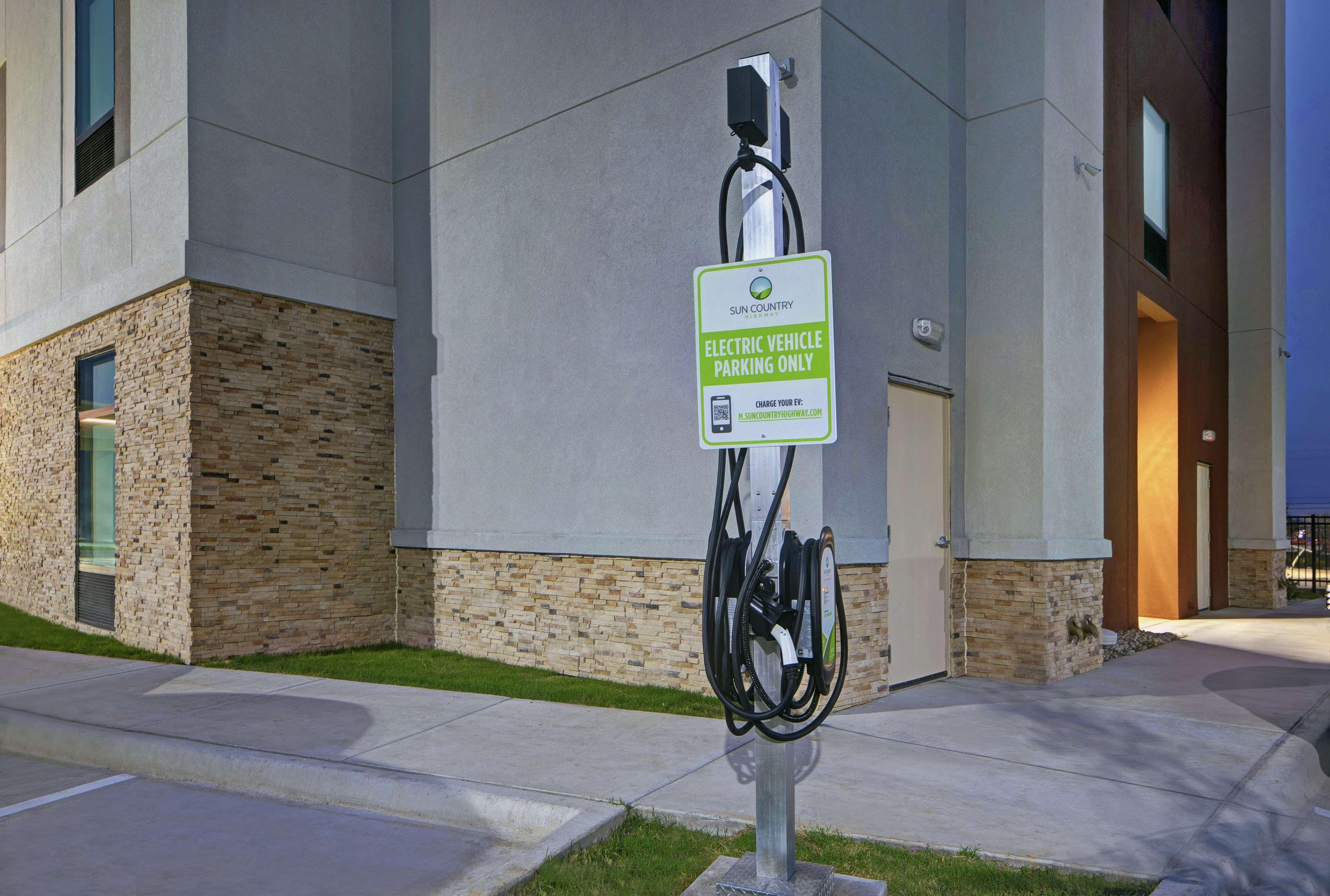Una estación de carga para vehículos eléctricos, con un cartel que indica que es solo para vehículos eléctricos.
