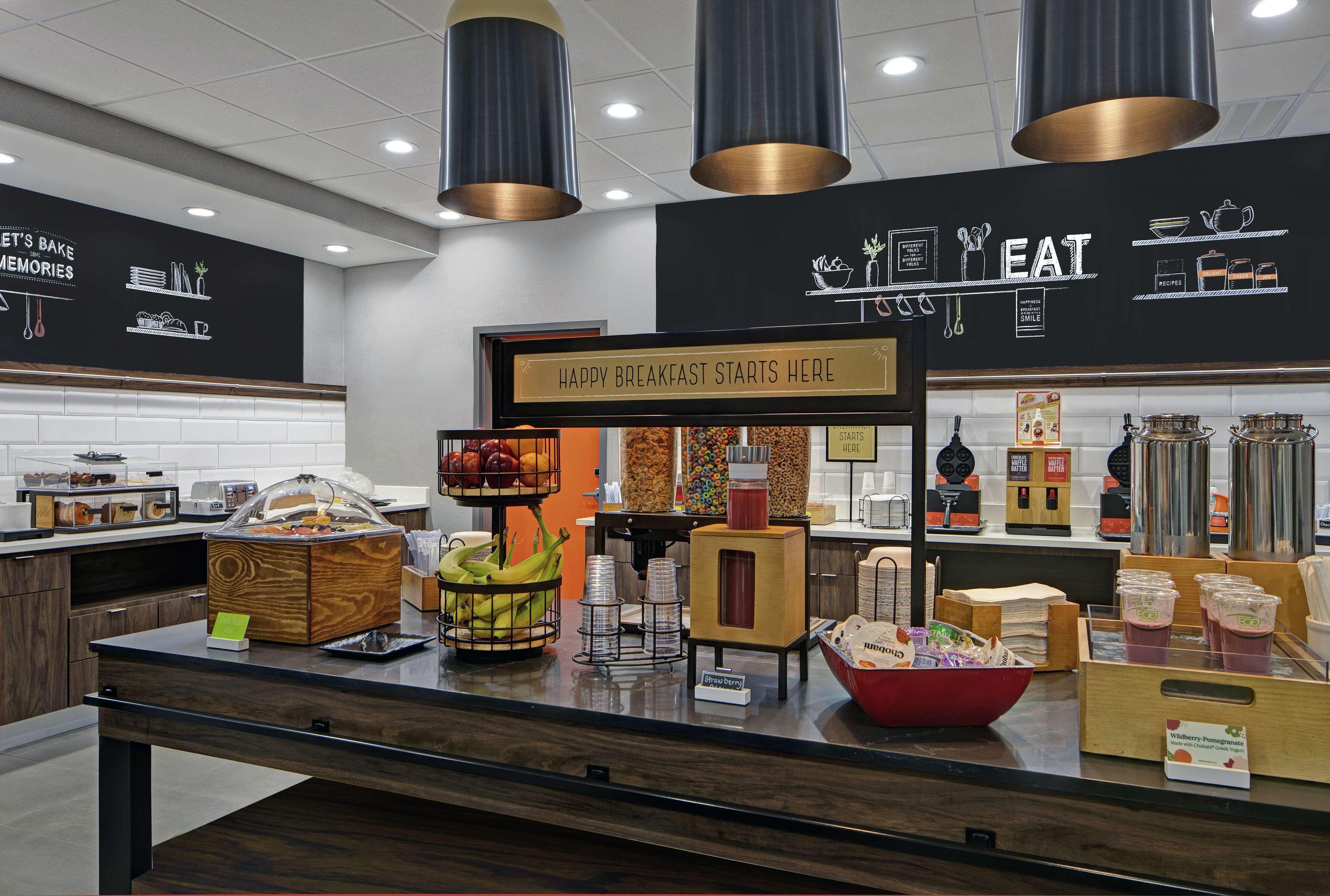 A breakfast buffet area with a sign that reads "HAPPY BREAKFAST STARTS HERE."
