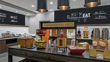 A breakfast buffet area with a sign that reads "HAPPY BREAKFAST STARTS HERE."