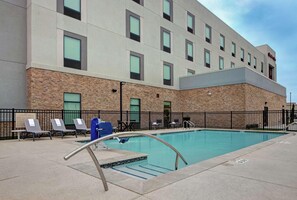 A hotel with a swimming pool, outdoor seating, and a stone facade. - Hampton Inn Weslaco (Weslaco)