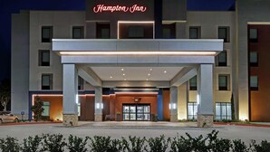 Un hôtel Hampton Inn doté d’une façade moderne, d’une grande entrée et d’une enseigne lumineuse.