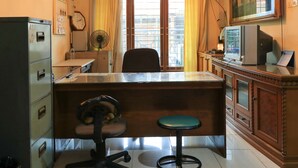 A room with a desk, chair, and a large window with curtains. - Guest House Samarinda (Samarinda)