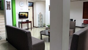 A living room with a television, a coffee table, and seating. - Saidah Guest House (Bandung)